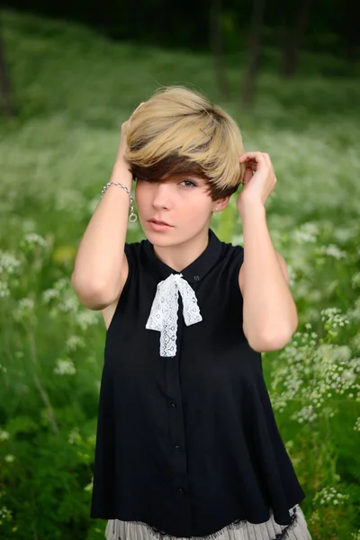 Vacker flicka på en bakgrund av grönt gräs — Stockfoto
