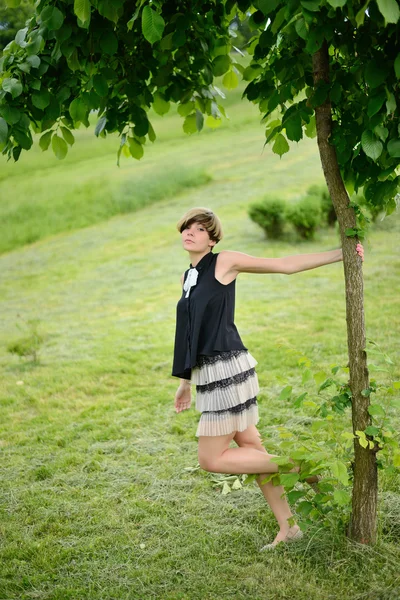 Schönes Mädchen posiert in einem grünen Park — Stockfoto
