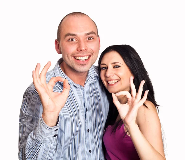 Closeup of good looking young couple gesturing okay sign over wh — Stock Photo, Image
