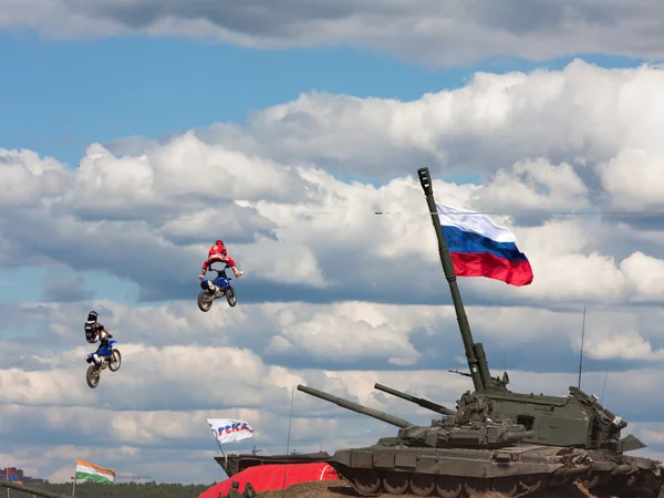 Saltando em uma bicicleta sobre tanques de batalha — Fotografia de Stock