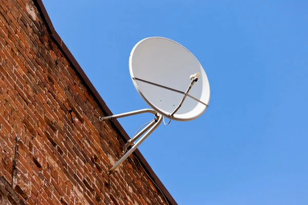 Anteny satelitarnej montowane na stary ceglany mur. — Zdjęcie stockowe