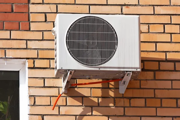 Airconditioning warmtepomp gemonteerd op bakstenen muur. — Stockfoto
