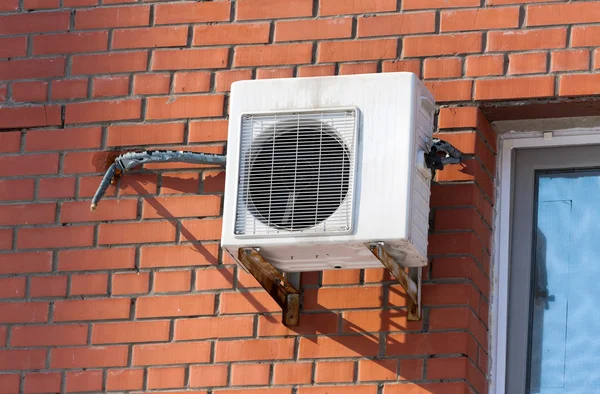 Aire acondicionado bomba de calor montada en la pared de ladrillo. — Foto de Stock