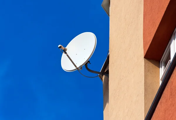 Uydu anteni mavi gökyüzü adam tuğla duvara monte — Stok fotoğraf