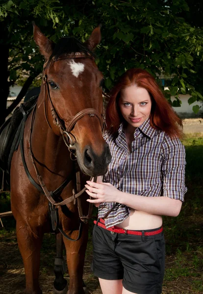 Kobieta z czerwonych włosach siedzi na koniu — Zdjęcie stockowe