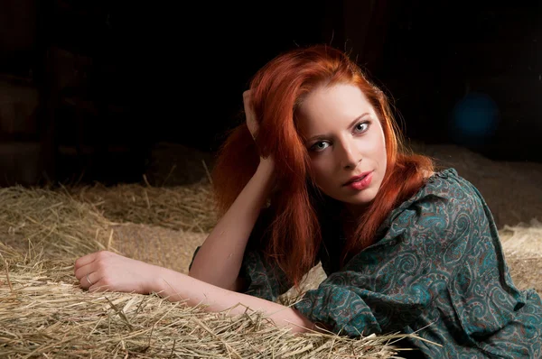 Woman lying on a haystack — Stock Photo, Image