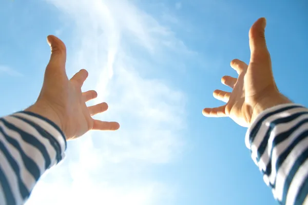 Mãos no ar através do céu azul — Fotografia de Stock