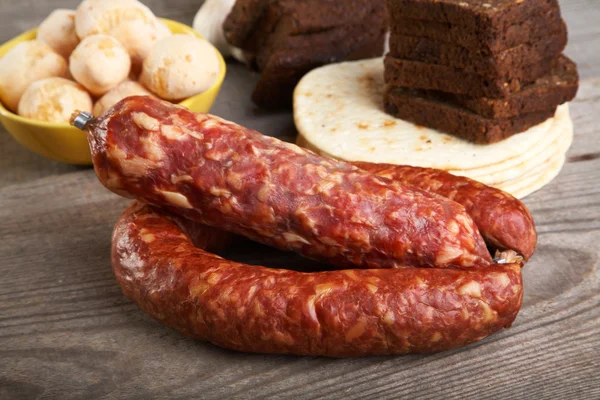 Still-life with sausage and bread on a table — Stock Photo, Image