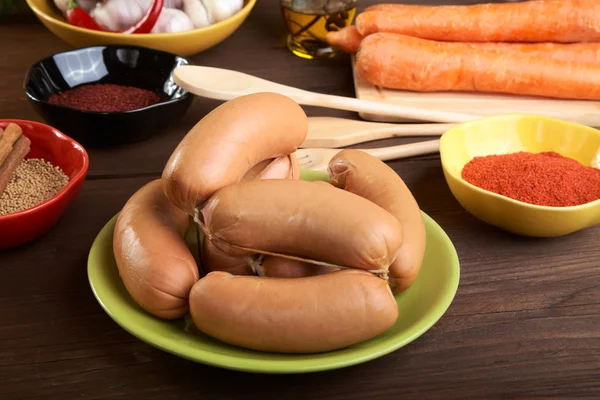 Korv med kryddor och grönsaker på ett träbord — Stockfoto