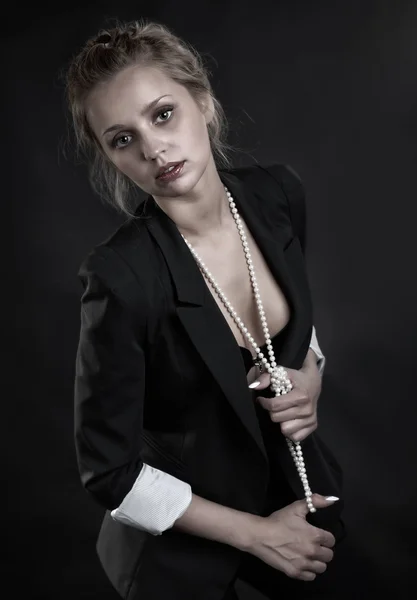 Das Mädchen im Büstenhalter und Perlen auf schwarz — Stockfoto