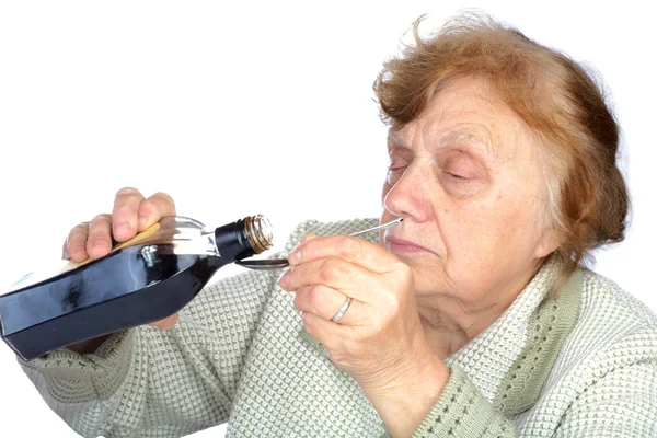 Büyükanne bir ilaç üzerinde beyaz izole kaşık olarak dökülen — Stok fotoğraf