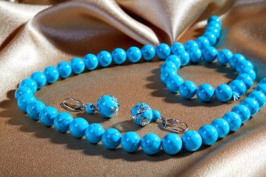 Blue necklace and earrings on a brown clipart