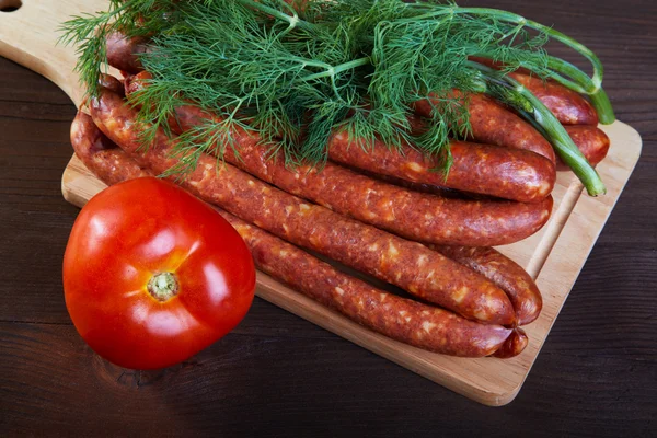 Sausage fennel and a tomato on an wooden table — Stock Photo, Image