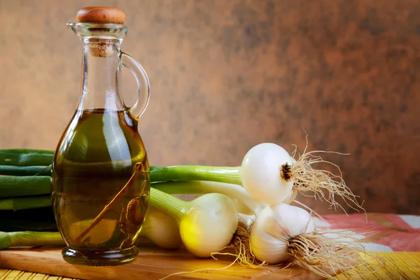 Onion and garlic with an olive oil bottle — Stock Photo, Image