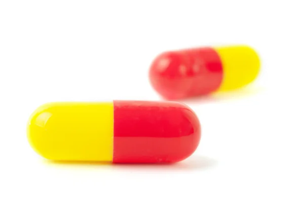 Две красно-желтые таблетки — стоковое фото