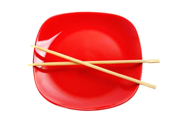 Roter Teller mit chinesischen Stöcken — Stockfoto