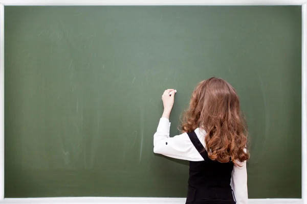 Školačka píše na tabuli — Stock fotografie
