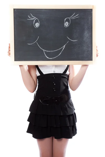 Mädchen versteckt sich hinter einer Tafel mit dem Bild des Lächelns — Stockfoto