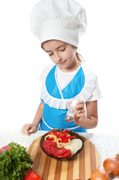 Pequeno chef feliz cozinhar sais salada — Fotografia de Stock