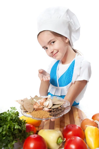 Happy little chef cook offers a plate with spices — Stock Photo, Image