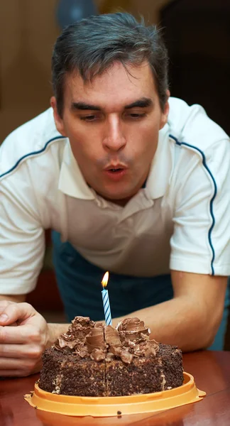 Homme soufflant bougie d'anniversaire Images De Stock Libres De Droits