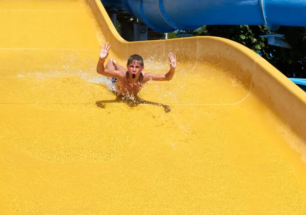 Rapaz rolando com slide no parque aquático — Fotografia de Stock