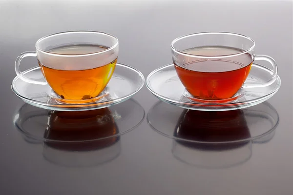 stock image Transparent cup with green and black tea