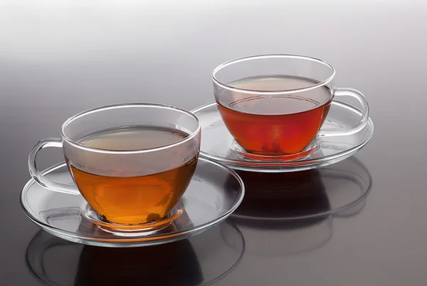 Stock image Transparent cup with green and black tea