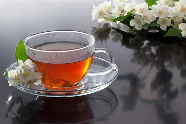 Прозрачная чашка с зеленым чаем и свежими жасминовыми цветами — стоковое фото