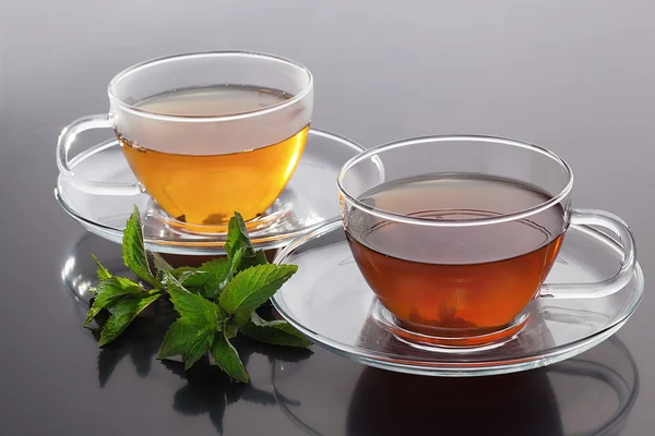 Прозрачная чашка с зеленым чаем и свежими листьями мяты — стоковое фото