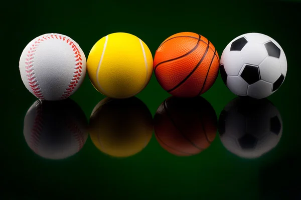 Спортивные мячи на черном фоне — стоковое фото