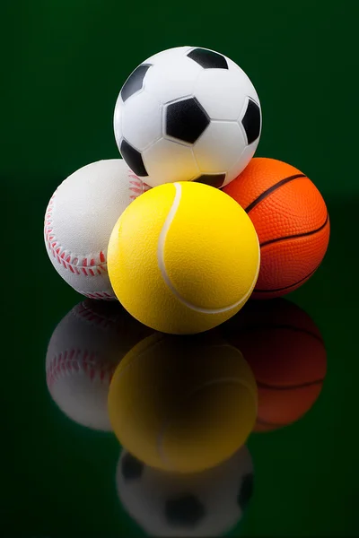 Спортивные мячи на черном фоне — стоковое фото