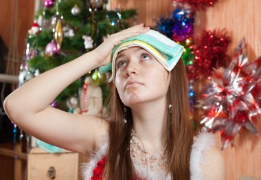 Woman in christmas hat having hangover clipart