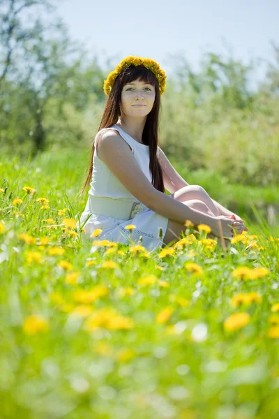 タンポポの草原に座っている女の子 — ストック写真