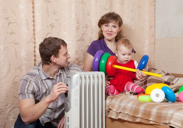 Familia en casa cerca del calentador de aceite —  Fotos de Stock