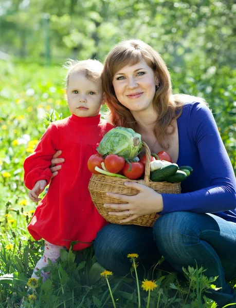 Счастливая семья с овощами в саду — стоковое фото