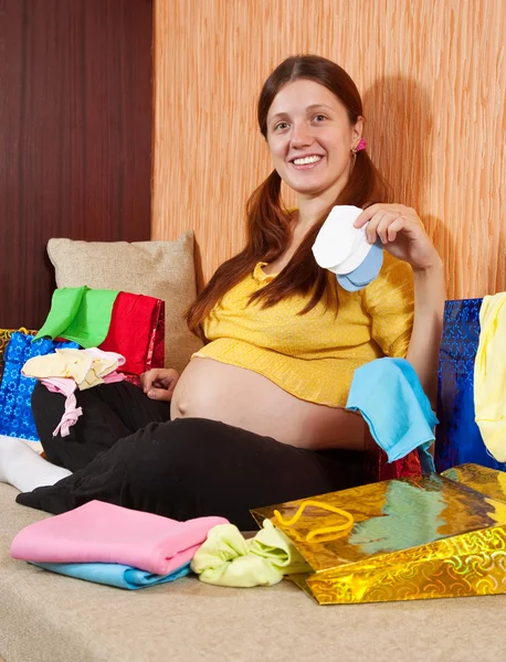 赤ちゃんの服で妊娠中の女性 — ストック写真