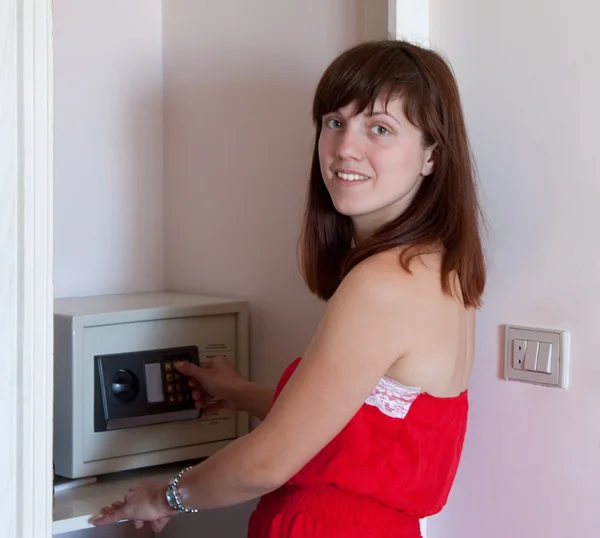 Женщина использует сейф в номере отеля — стоковое фото