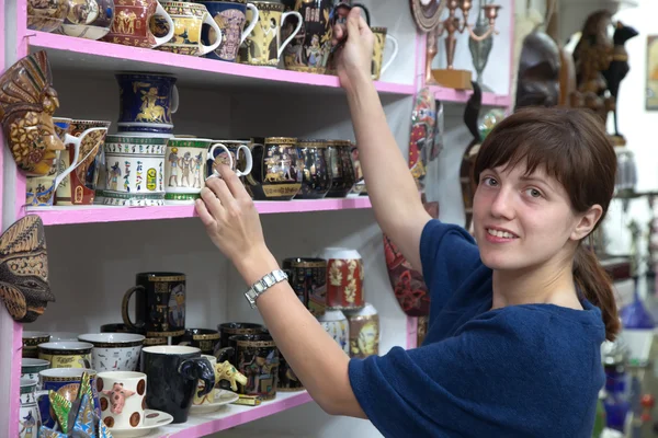 Donna sceglie tazza souvenir — Foto Stock