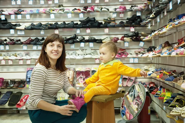 Donna con bambino sceglie scarpe bambino — Foto Stock