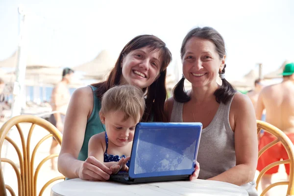 Family with laptop at resort beach — Stock Photo, Image
