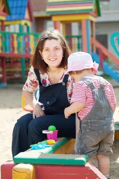 Mother with toddler in sandbox — Stock Photo, Image