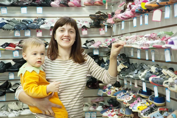 Madre con niño elige zapatos de bebé —  Fotos de Stock