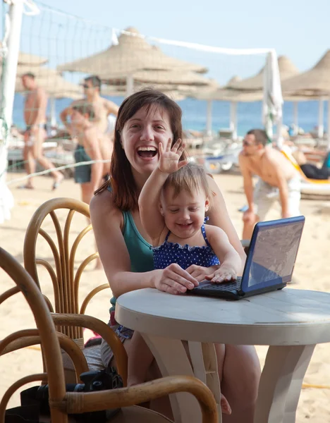 Happy mother and toddler with laptop at beach — Stock Photo, Image