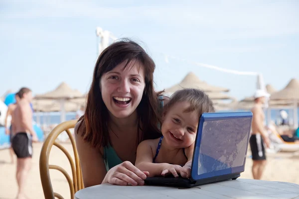 Happy family with laptop at beach — Stock Photo, Image