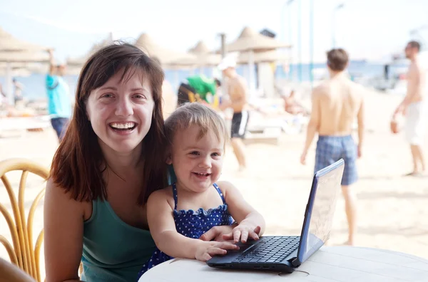 Mãe feliz e criança com laptop na praia — Fotografia de Stock