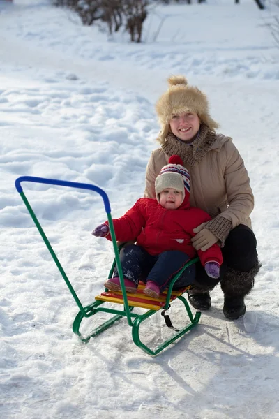 Happy mother with toddler on sled — Stock Photo, Image