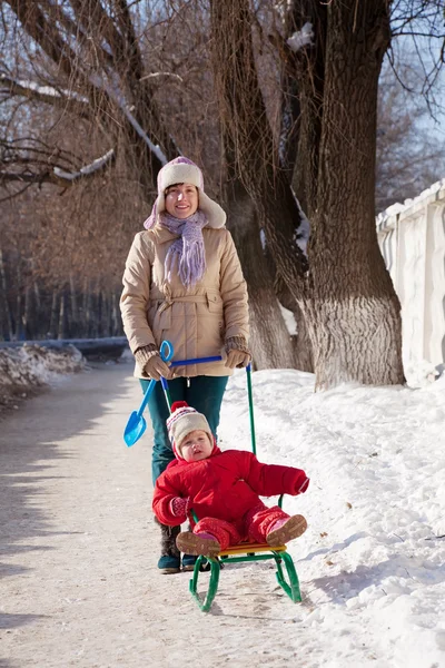 Mãe com criança no trenó no inverno — Fotografia de Stock