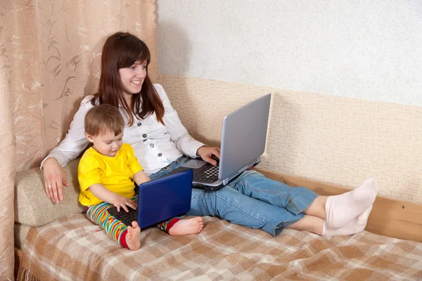 Mujer feliz con niño usando computadoras portátiles —  Fotos de Stock