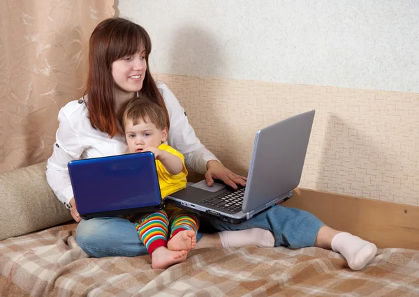 Feliz madre e hijo con computadoras portátiles — Foto de Stock